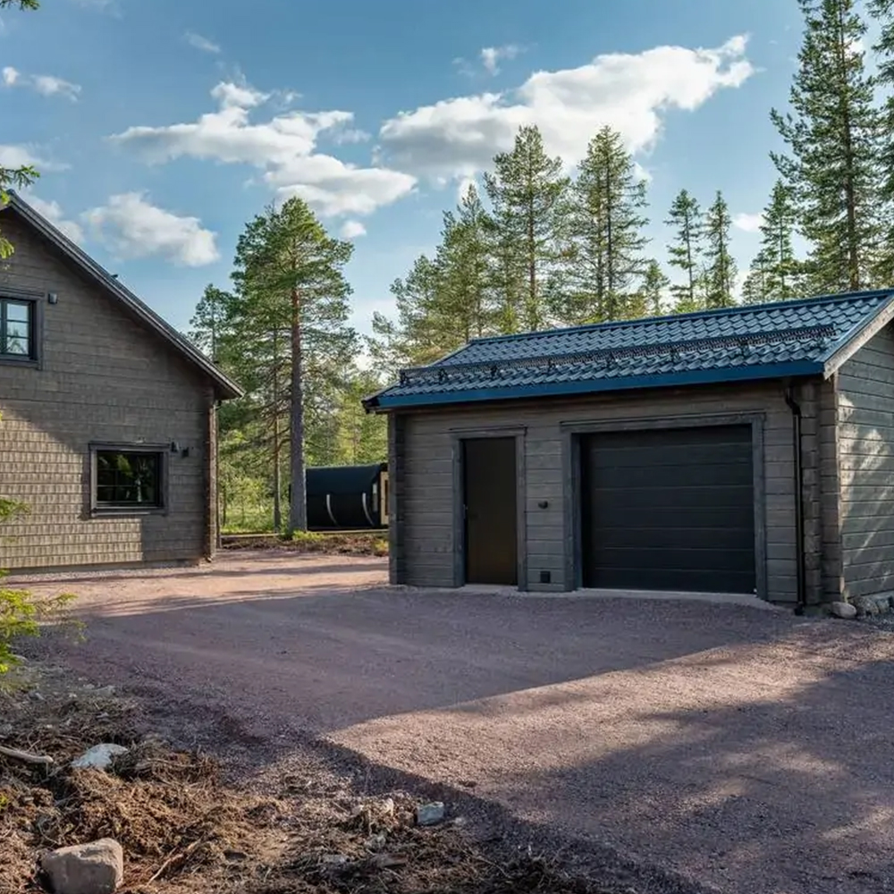 Fjällstuga med garage och förråd i rustik lodge-stil.