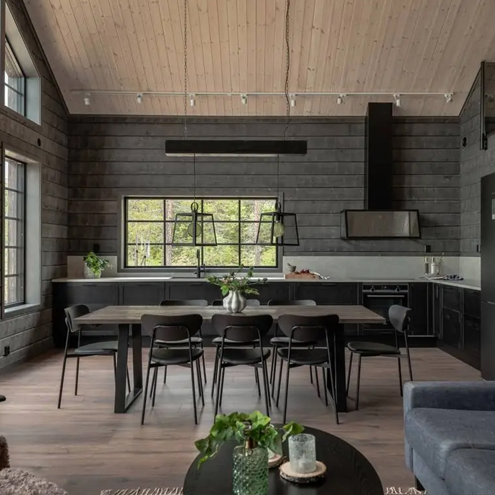 Fjällhusets kök med trädetaljer och stora fönsterpartier.