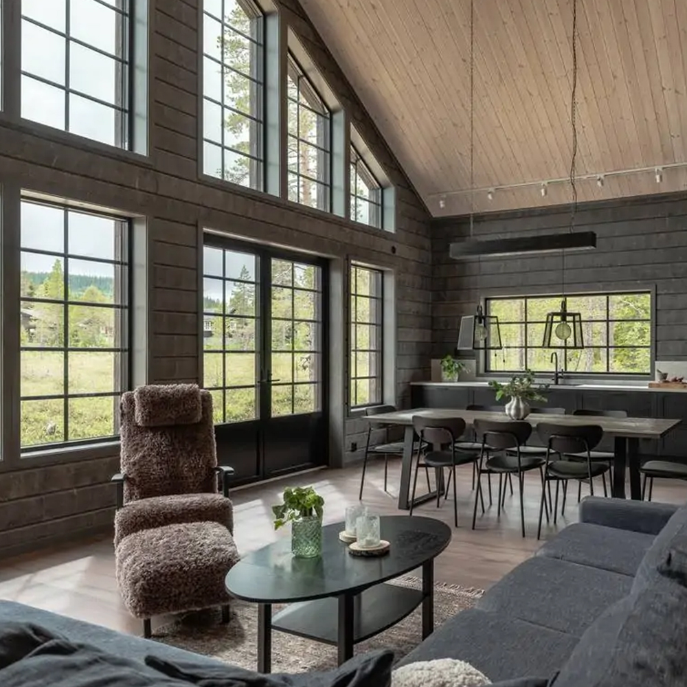 Interiör av nyckelfärdigt fjällhus med stora fönster och modernt kök.
